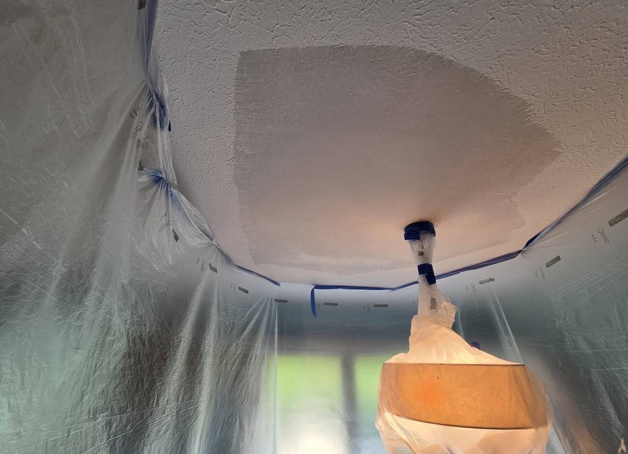 Drywall ceiling texture match in Louisville with protected fixture and plastic containment, ready for painter