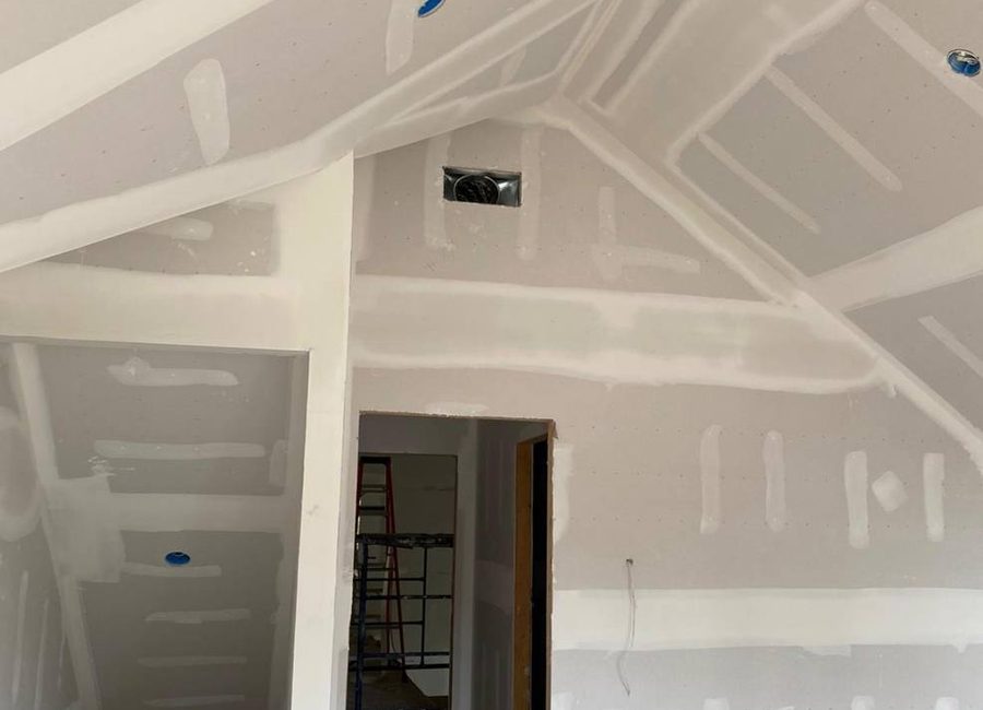 In-progress Louisville drywall finishing on sloped ceiling and stairwell with taped seams, mudded joints, recessed light boxes, and protected flooring